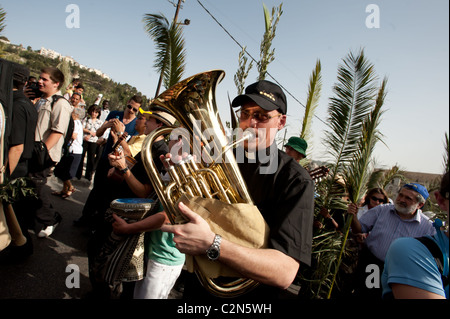 Con musica e rami di palma, cristiani commemorare il cammino di Gesù dal Monte degli Ulivi a Gerusalemme la Domenica delle Palme. Foto Stock