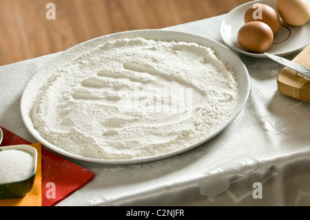 Impronta di una donna di mano in una ciotola con la farina Foto Stock