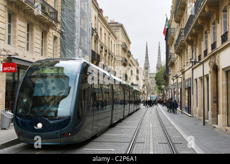 Il tram su Rue Vital-Carles con guglie del Duomo St Andre in background, Quartier St Pierre, Bordeaux Aquitania, Francia Foto Stock