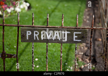 Segno privato sul vecchio arrugginito cancello del giardino Foto Stock