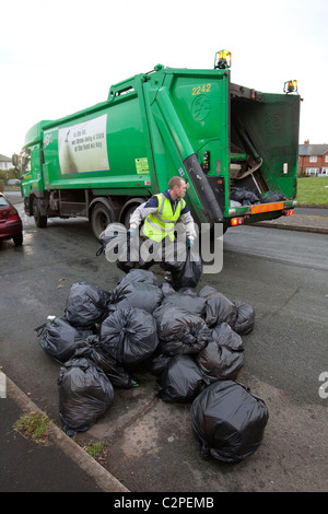 Sacchetti di rifiuti domestici vengono prelevate da un raccoglitore di rifiuti a Birmingham, Regno Unito Foto Stock