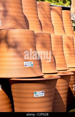 In terracotta di grandi vasi per piante impilati insieme a un giardino rivenditore di materiali di consumo Foto Stock