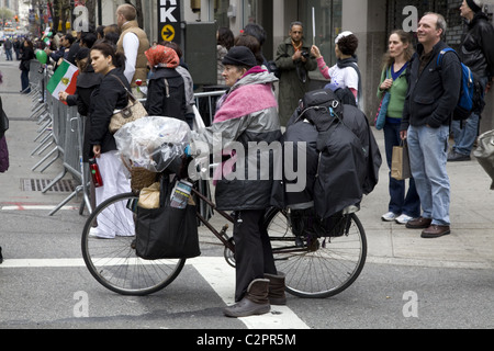 Donna con tutti i suoi averi per la sua bicicletta attende per attraversare la Madison Avenue durante il Persiano Parade di NYC, Foto Stock