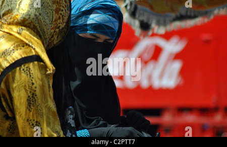 Donne arabe in burqas davanti a una Coca Cola carrello in Marocco Foto Stock