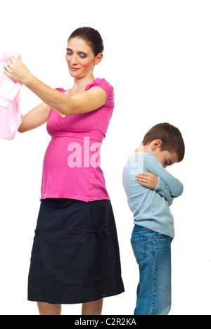 Geloso kid in piedi con le braccia piegate e guardando verso il basso mentre la madre di ammirare un nuovo baby vestiti isolati su sfondo bianco Foto Stock