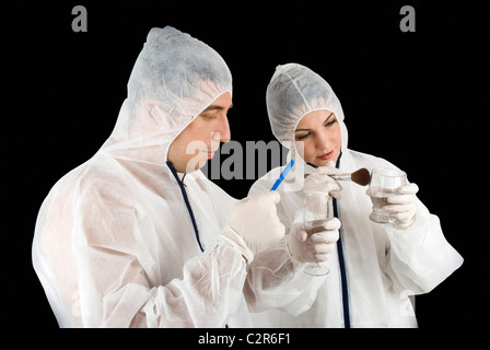 Due criminologi indagare un crimine e si raccolgono le prove di reato posto ,la donna detective hanno un vetro Foto Stock