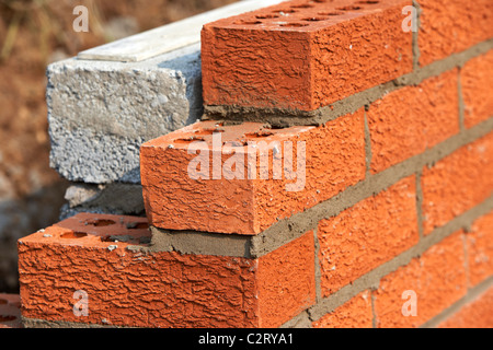 Parete di muratura red house mattoni rivolta verso la metà brezza di cemento blocca la costruzione di un blocco di parete di ritegno nel Regno Unito Foto Stock