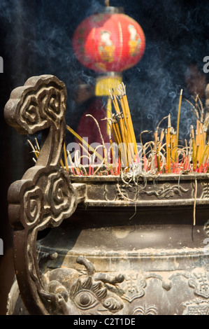 Chiudere verticale di bruciare incenso in grande incensiere a Tran Quoc Pagoda (Chùa Trấn Quốc) tempio buddista sul Lago Ovest di Hanoi. Foto Stock