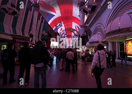 I turisti su Fremont Street Las Vegas, Nevada. La luce esterna e sound show sul tetto curvo. Unione Jack essendo mostrato. Foto Stock