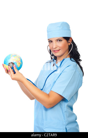 Attraente medico donna in piedi nel profilo di semi e di esaminare un globo mondo con il suo stetoscopio isolati su sfondo bianco Foto Stock