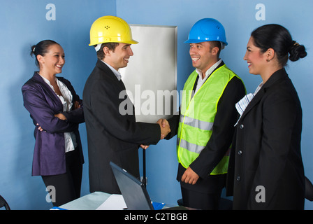 Architetto di due uomini che danno la mano scuote e donna ingegnere ridere insieme e divertirsi Foto Stock