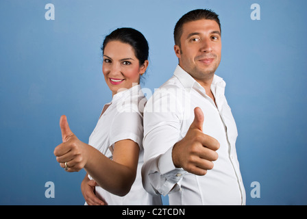 Paio di gente di affari ,l'uomo e la donna vestita di bianco Shirt dando pollice in alto su sfondo blu Foto Stock