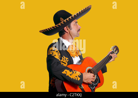 Charro Mariachi suonando la chitarra su sfondo giallo Foto Stock