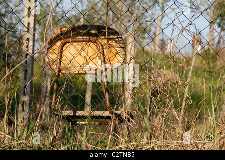 Una sola sedia vecchia sinistra in campo in campagna Foto Stock