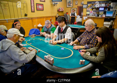 I giocatori di diverse fasce di età e gare di giocare a Texas Hold'em poker presso un negozio di fronte casino di Merced, CA. Foto Stock