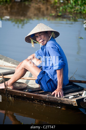 Pescatore vietnamita in un invaso campo di riso Foto Stock
