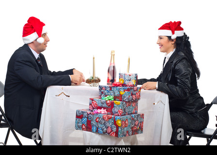 Coppia felice con cappelli di Babbo Natale una conversazione a cena di Natale tabella Foto Stock