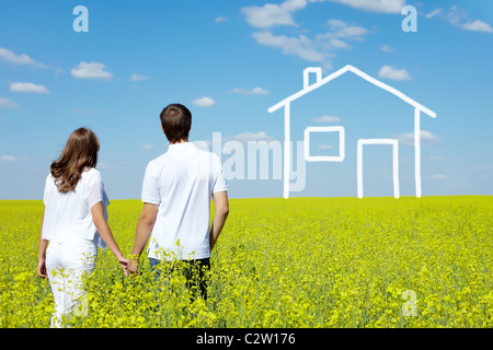 Vista posteriore della coppia amorosa nel prato giallo guardando tracciata house Foto Stock