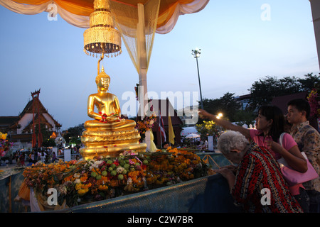 I thailandesi si versa acqua sulla statua di Budda durante il Songkran Anno Nuovo Festival di Bangkok Foto Stock