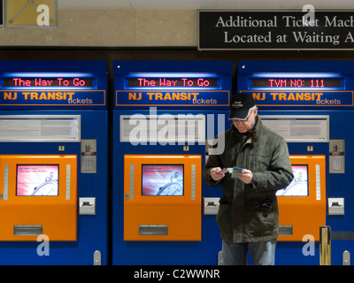 L'uomo Acquisto di New Jersey Transit i biglietti del treno a Self Service Distributore, Penn Station, NYC Foto Stock