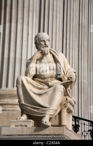 Austria, Vienna, seduto statua del filosofo greco Erodoto nella parte anteriore delle colonne del palazzo del Parlamento. Foto Stock