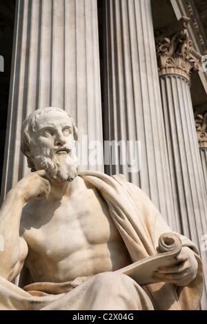 Austria, Vienna, seduto statua del filosofo greco Erodoto nella parte anteriore delle colonne del palazzo del Parlamento. Foto Stock