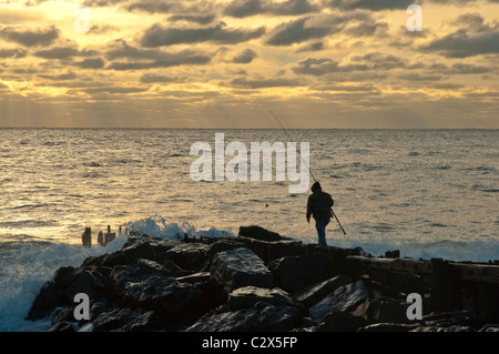 Fisherman sulle rocce al surf in mattina presto nel ramo lungo, NJ Foto Stock