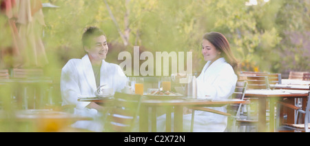 Giovane gustando la prima colazione sul patio esterno Foto Stock
