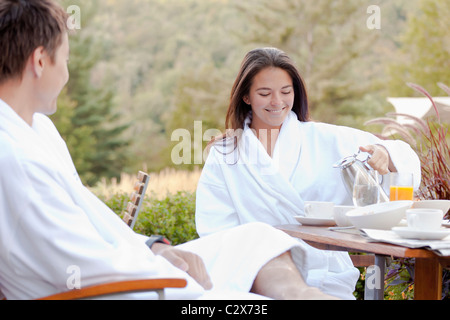 Giovane gustando la prima colazione sul patio esterno Foto Stock