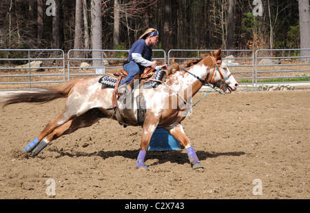Giovane donna bionda Barrel racing Foto Stock
