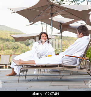 Giovane gustando la prima colazione vicino alla piscina Foto Stock