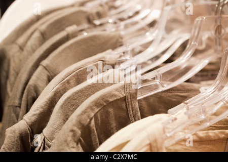 Close up di camicie appesi su grucce per indumenti Foto Stock