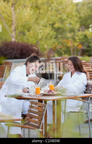 Giovane gustando la prima colazione sul patio esterno Foto Stock