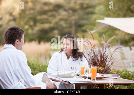Giovane gustando la prima colazione sul patio esterno Foto Stock
