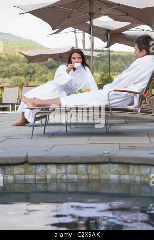 Giovane gustando la prima colazione vicino alla piscina Foto Stock