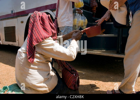 Un uomo è dare soldi a un anziano handicappati donna affamati che vivono in condizioni di povertà in Kampong Cham Provincia, in Cambogia. Foto Stock