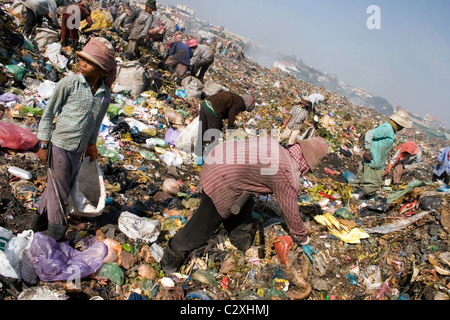 Lavoratori, inclusi lavoratori minorenni, sono la raccolta di materiali riciclabili in un tossico e inquinato garbage dump in Cambogia. Foto Stock