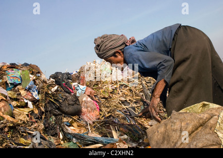 Una donna anziana è la ricerca di materiale riciclabile a inquinata discarica di rifiuti in Cambogia. Foto Stock