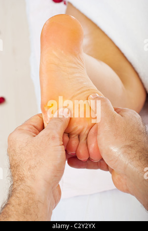 In prossimità delle mani dell'uomo donna massaggio il piede Foto Stock