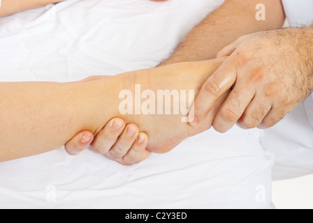 Dettaglio di ortopedico maschio massaggio mani womans piede Foto Stock