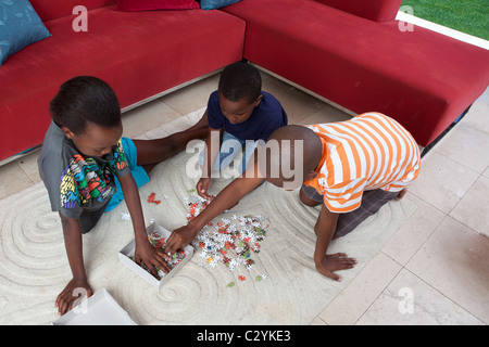 I fratelli a giocare con un puzzle sul tappeto, Johannesburg, Sud Africa Foto Stock