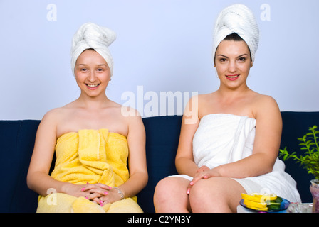 Due donna felice seduta sul lettino a spa resort in una sala di attesa e sorridente Foto Stock
