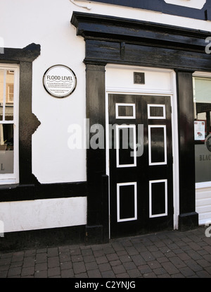 La placca che mostra 2009 flood'altezza di livello di acqua dalla porta di Black Bull pub nel centro della città. Main St Cockermouth Cumbria Inghilterra England Regno Unito Foto Stock