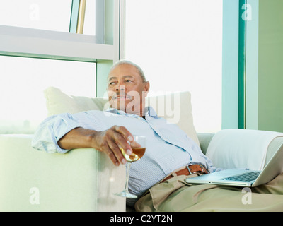 Uomo nero bere il vino e libro di lettura Foto Stock