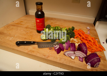 Tagliare le verdure pronte per essere saltate in padella con una bottiglia di stir fry sauce Foto Stock