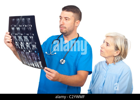 Medico grave uomo che mostra i risultati della formazione di immagini a risonanza magnetica a un senior paziente ed essendo entrambi preoccupati isolato su bianco Foto Stock