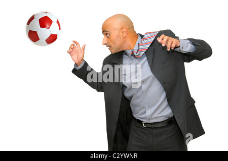 Imprenditore a giocare con un pallone da calcio isolati in bianco Foto Stock