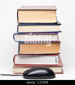 Pila di libri con copertina rigida e mouse nero Foto Stock