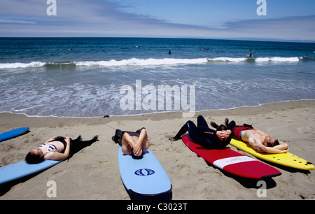 Surfers rilassarvi sulla spiaggia di Pacifica Foto Stock