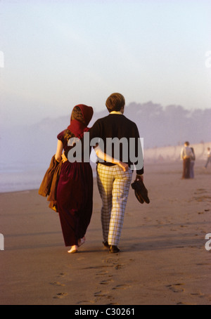 Due giovani innamorati passeggiare a piedi nudi sulla sabbia sulla spiaggia dell'oceano di San Francisco Foto Stock